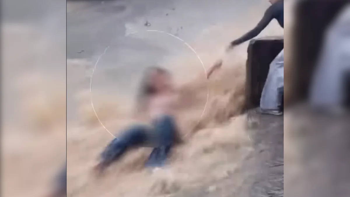 Jovem é resgatada após ser arrastada por enxurrada na rua e parar em poste