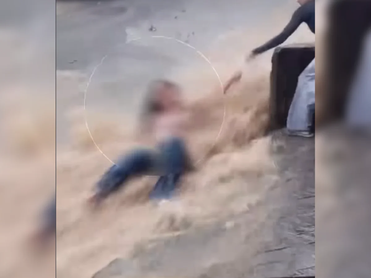 Jovem é resgatada após ser arrastada por enxurrada na rua e parar em poste